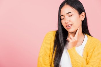 Portrait of Asian beautiful young woman has chin pain, female painful use finger touching itching his chin, studio shot isolated on pink background, Health and medical problem and Dental care concept