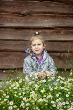 Portrait of cute little girl near the wooden fence in the village.. Portrait of cute little girl