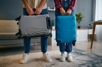 Married couple with suitcases in living room. Tourists before going on trip. Married couple with suitcases in living room.