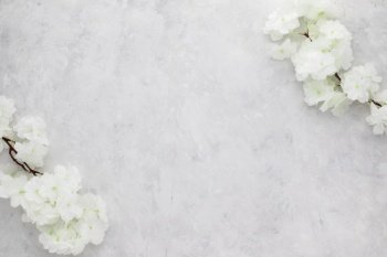 White flowers on white grunge background. Flat lay, top view with copy space, Minimalism