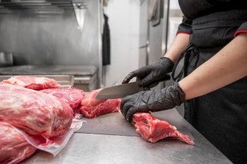 Close up of raw meat and woman butcher cutting meat with knife. High quality photo. Close up of raw meat and woman butcher cutting meat with knife.