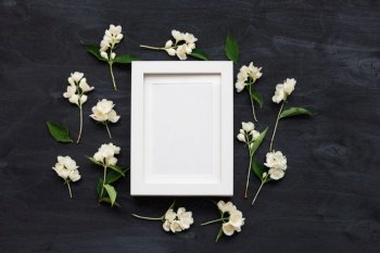 Flat lay top view mockup of a frame on a black background with wild flowers. Beautiful trendy layout photo.. Flat lay top view mockup photo of a frame on a black background with wild flowers.