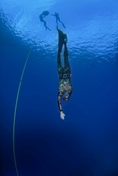 Freediver training with a line in the open sea. Freediver practising in the open blue water