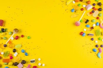 various colorful candies lollipops yellow surface. Resolution and high quality beautiful photo. various colorful candies lollipops yellow surface. High quality and resolution beautiful photo concept