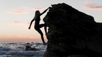 long shot woman climbing rock ocean. Resolution and high quality beautiful photo. long shot woman climbing rock ocean. High quality beautiful photo concept