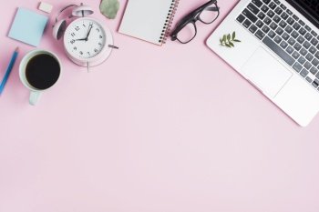 black tea cup alarm clock spiral notepad eyeglasses laptop pink backdrop