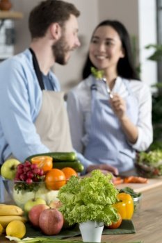 blurred focus couple feeding healthy salad standing kitchen counter