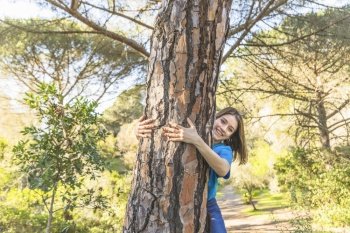 young woman hugging tree forest