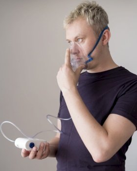 man standing using oxygen mask