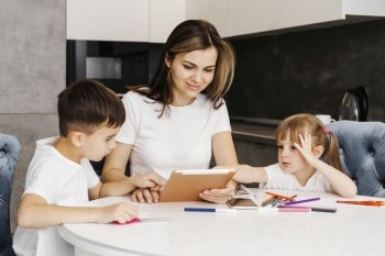mother with children learning home from digital tablet
