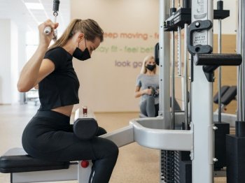 side view woman working out gym during pandemic