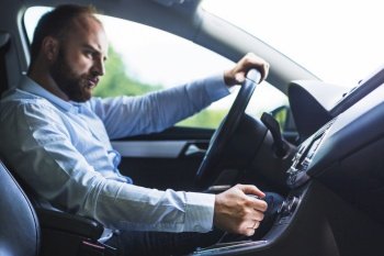 man shifting gear stick while driving car