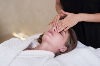 relaxed woman getting facial massage
