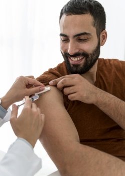 doctor vaccinating handsome bearded man