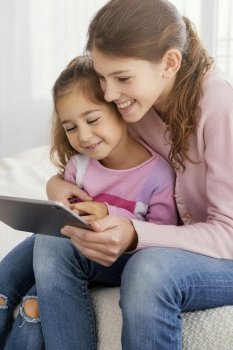 two sisters using tablet together home