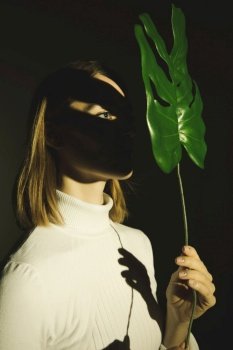 young woman holding green leaf face