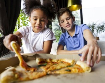 medium shot children holding pizza slices