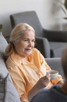 close up retired woman holding cup