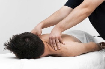 physiotherapist massaging man s back