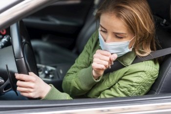 woman with protection mask her car coughing