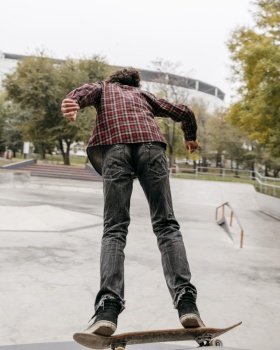 man enjoying skateboarding outside city park