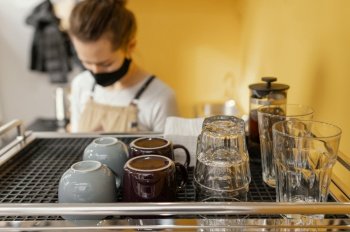 female barista with mask working coffee shop