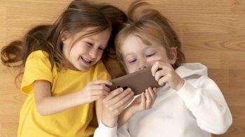 top view young kids using smartphone together
