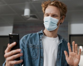 man wearing medical mask looking phone