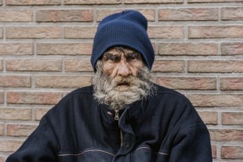 bearded homeless man front wall