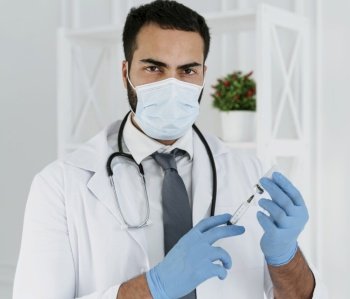 front view doctor with medical mask holding syringe