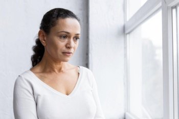 sad woman looking through window group therapy session
