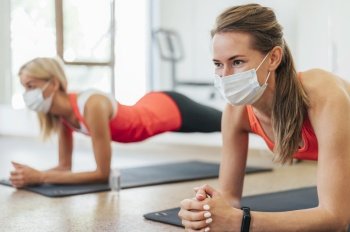 side view women with medical masks working out together