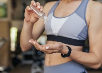 woman gym using hand sanitizer