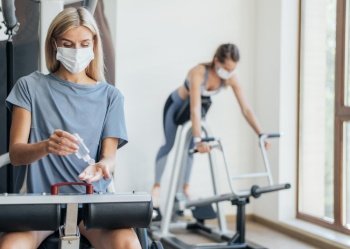 women exercising gym with medical mask
