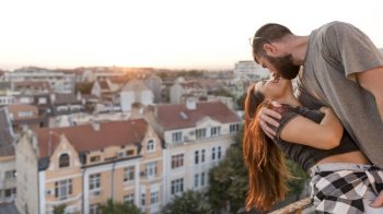 romantic couple kissing rooftop