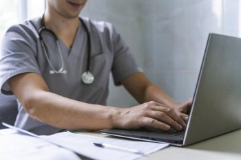 side view doctor with stethoscope working laptop