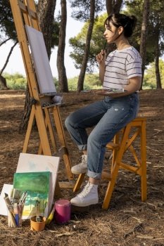 side view woman painting outdoors