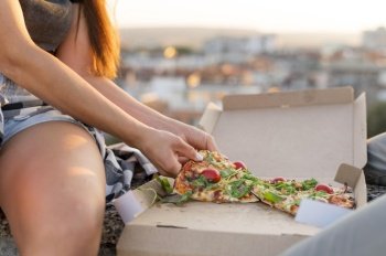 woman eating pizza outdoors