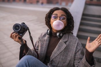 woman holding camera blowing bubbles