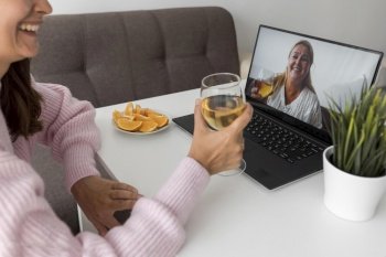 woman home quarantine having drink with friend laptop