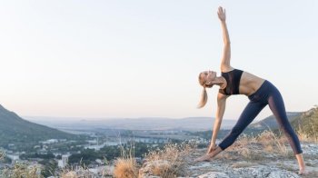 beautiful blonde woman practicing yoga outdoors