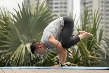 man practicing yoga position outside