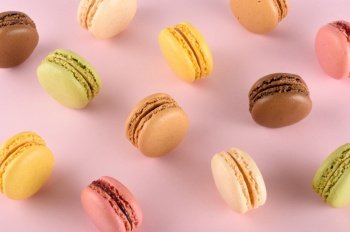 Original classic colorful french macarons assortment with different tastes on pink pastel background 