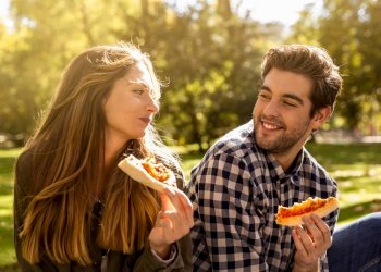 Friends at the park eating pizza