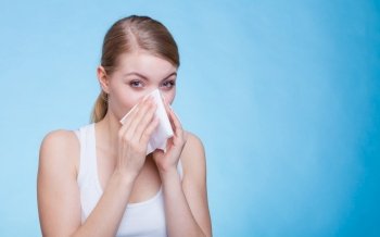 Disease, sickness, allergy, malady problem concept. Woman wiping her nose with hygienic paper tissue having cold and feeling bad.. Sick woman using paper tissue, headcold problem