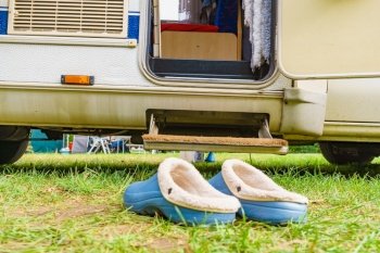 Shoes in front of camper car step. Travel in motorhome, holidays.. Shoes clogs in front of camper car step