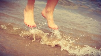 Happiness and craziness. Female legs feet in air jump on beach over water. Fun and freedom.. Female feet jump on beach.