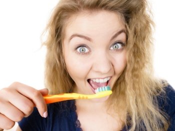 Happy crazy blonde woman brushing teeth having crazy tangled hair. Oral hygiene concept, isolated background.. Happy positive woman brushing teeth, isolated