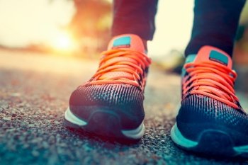 Running in the sunny summer day, closeup photo of a women’s sportive shoes, body part, female feet, training outdoors, healthy sportive lifestyle
