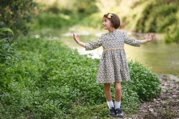 Little beautiful girl in nature stream wearing beautiful dress. Little girl in nature stream wearing beautiful dress